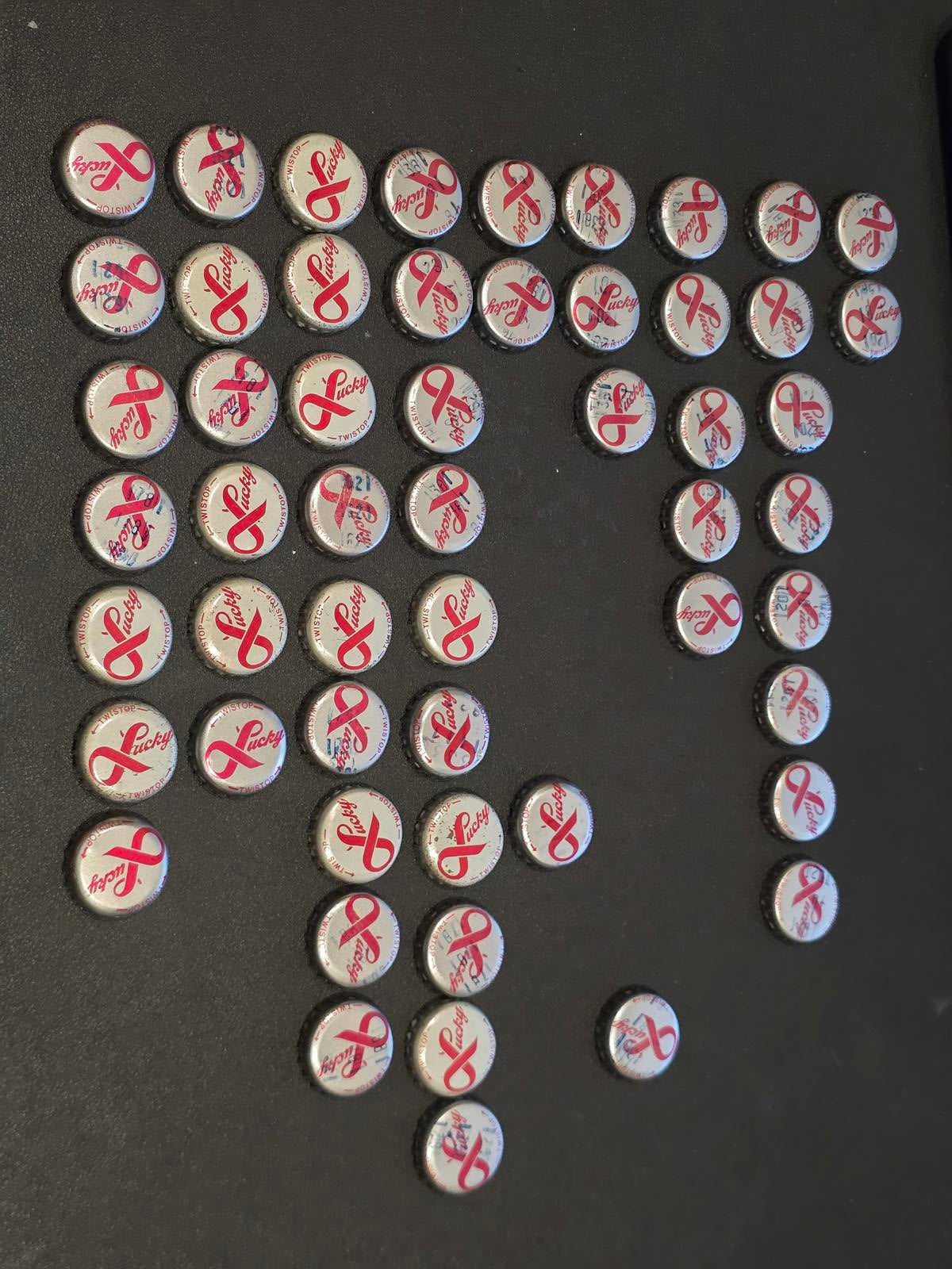 Set of 76 Lucky Lager Rebus/Puzzle Bottle Caps - Silver w/ Red Script
