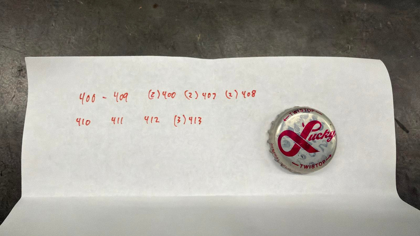 Set of 122 Lucky Lager Rebus/Puzzle Bottle Caps - Silver w/ Red Script