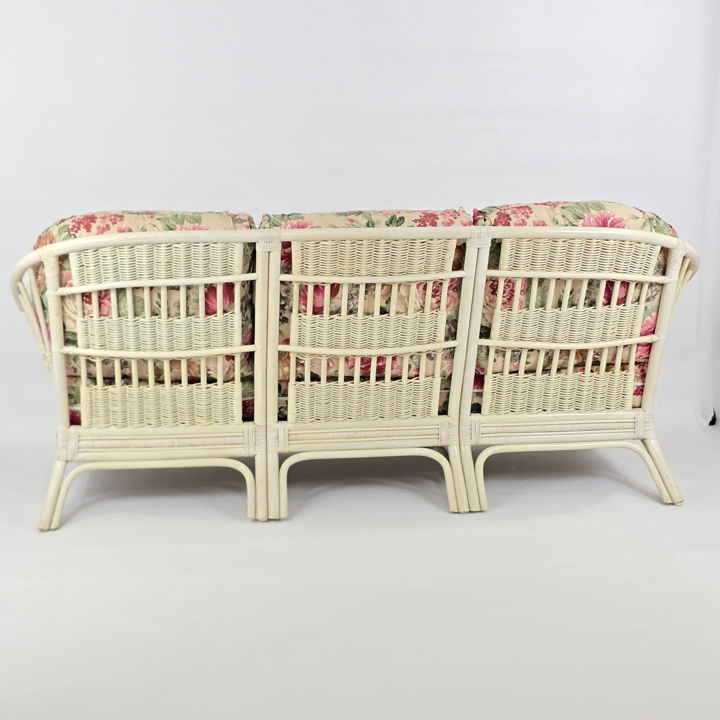 Whitewashed Rattan Sofa with Floral Cushions