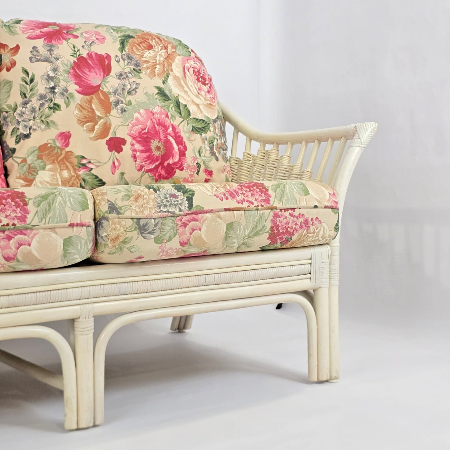 Whitewashed Rattan Sofa with Floral Cushions