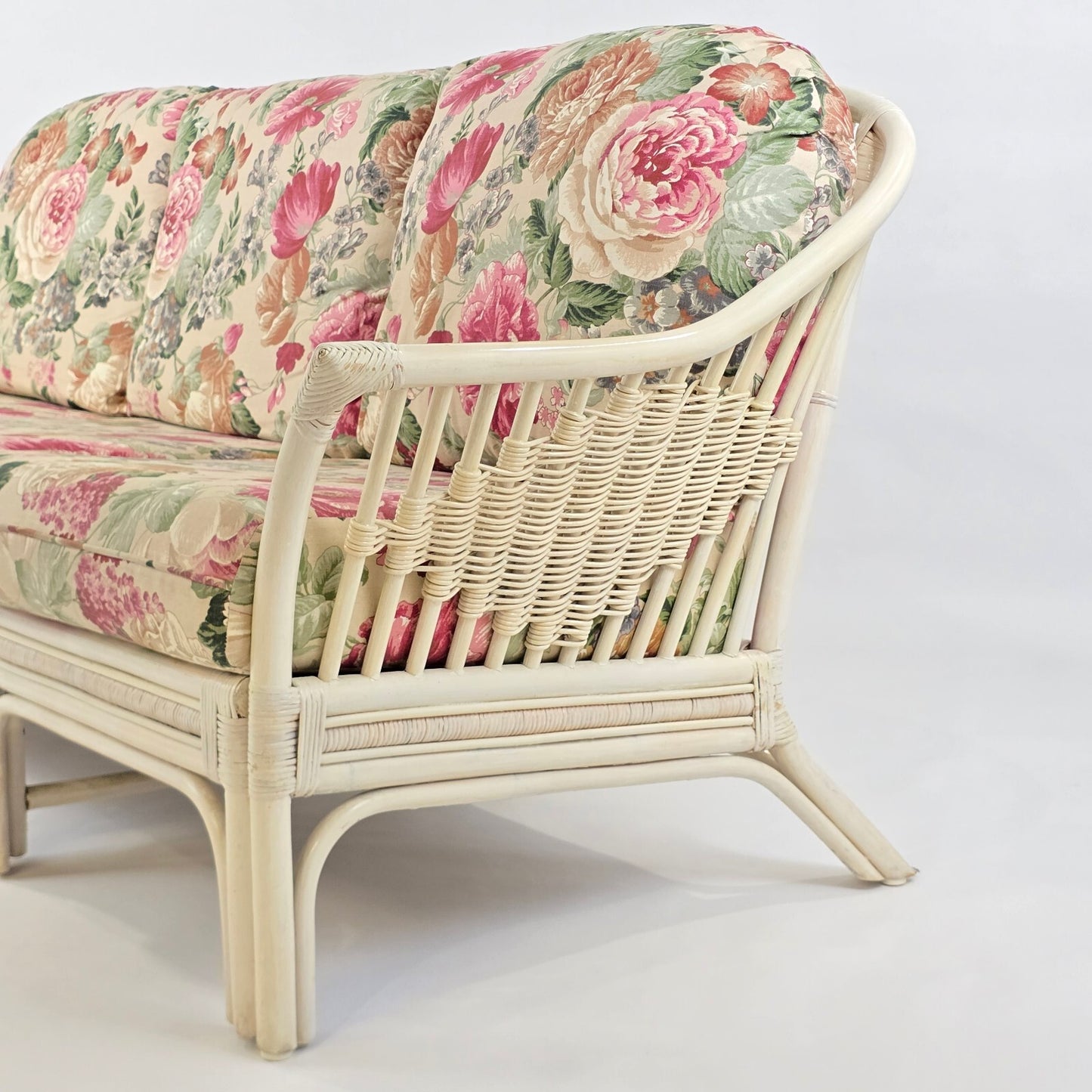 Whitewashed Rattan Sofa with Floral Cushions