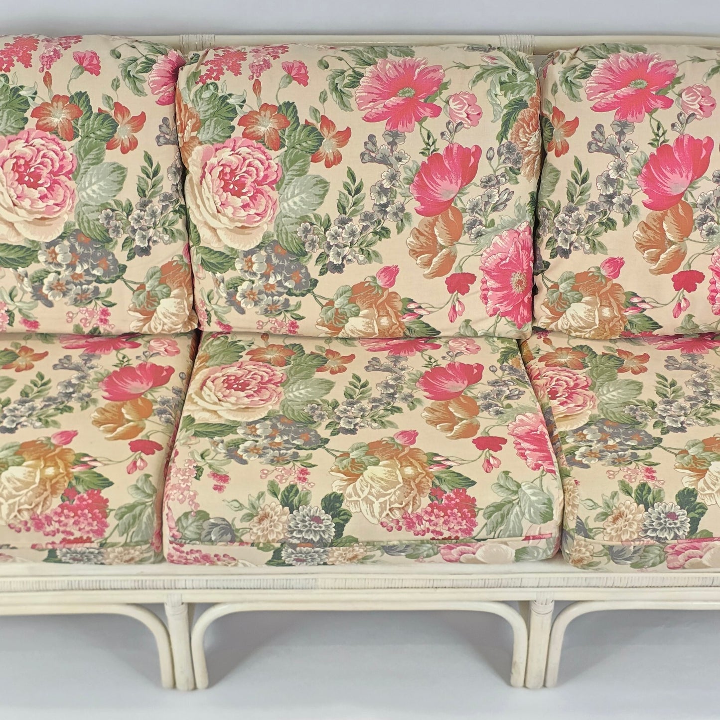 Whitewashed Rattan Sofa with Floral Cushions