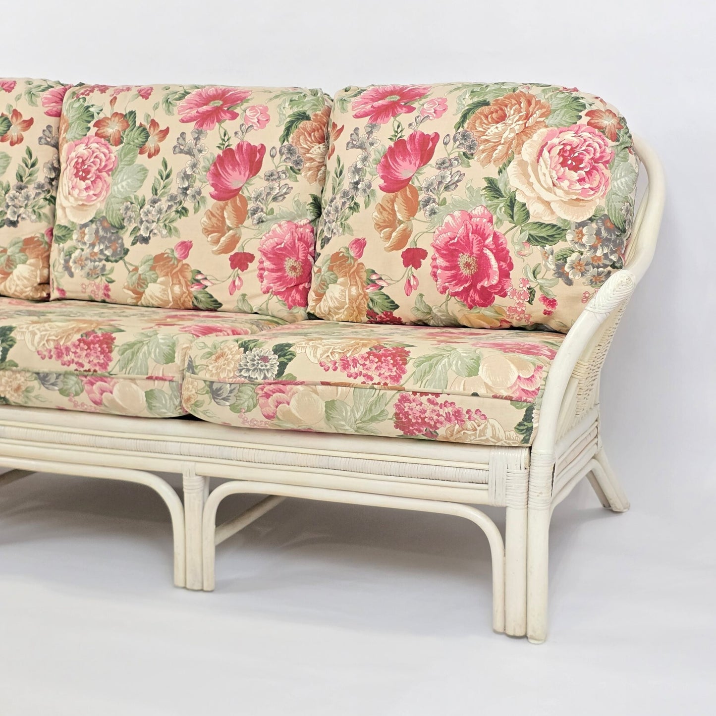 Whitewashed Rattan Sofa with Floral Cushions