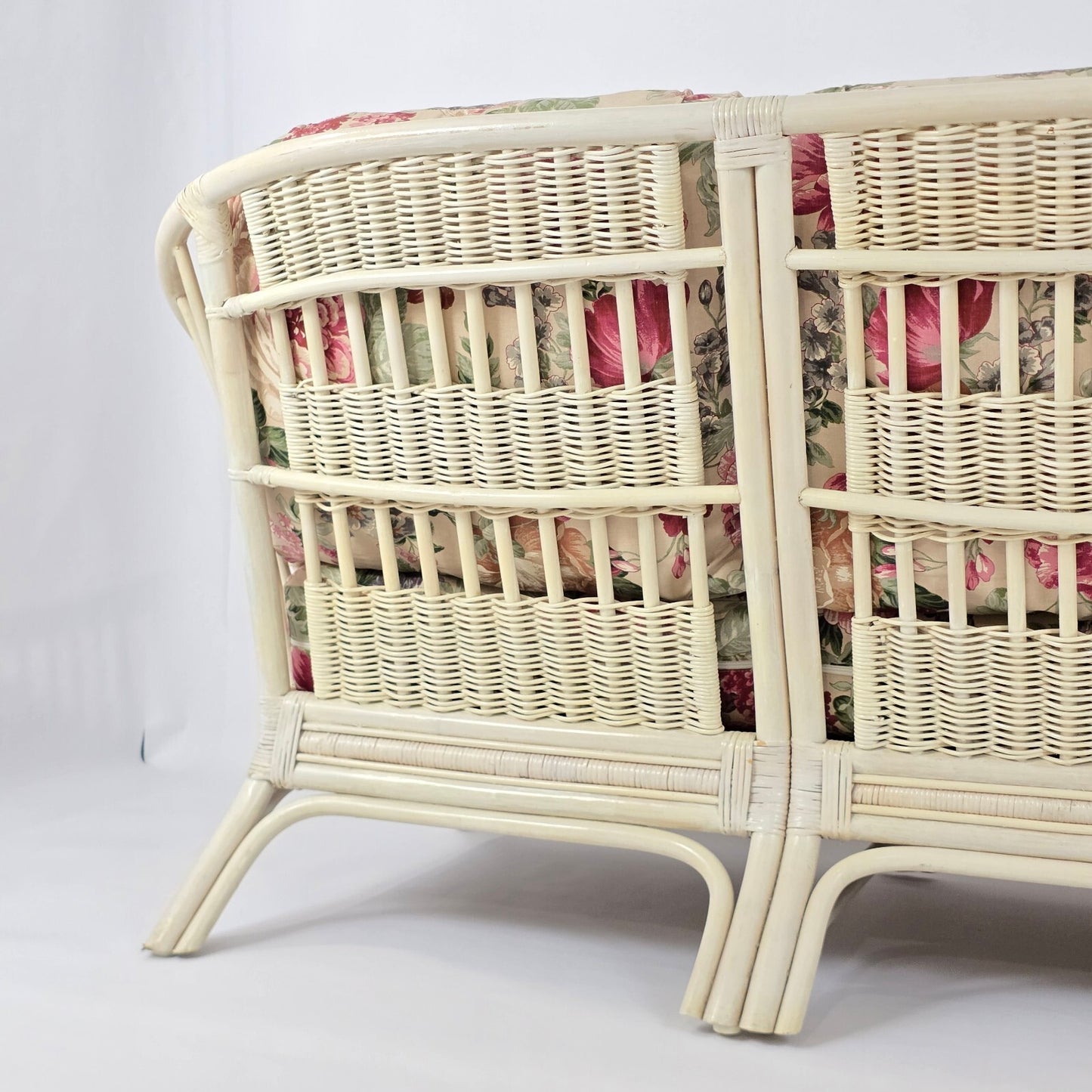 Whitewashed Rattan Sofa with Floral Cushions