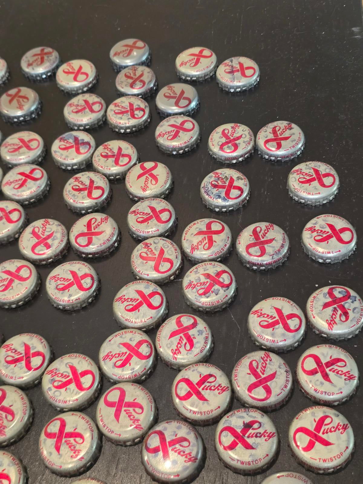 Set of 122 Lucky Lager Rebus/Puzzle Bottle Caps - Silver w/ Red Script