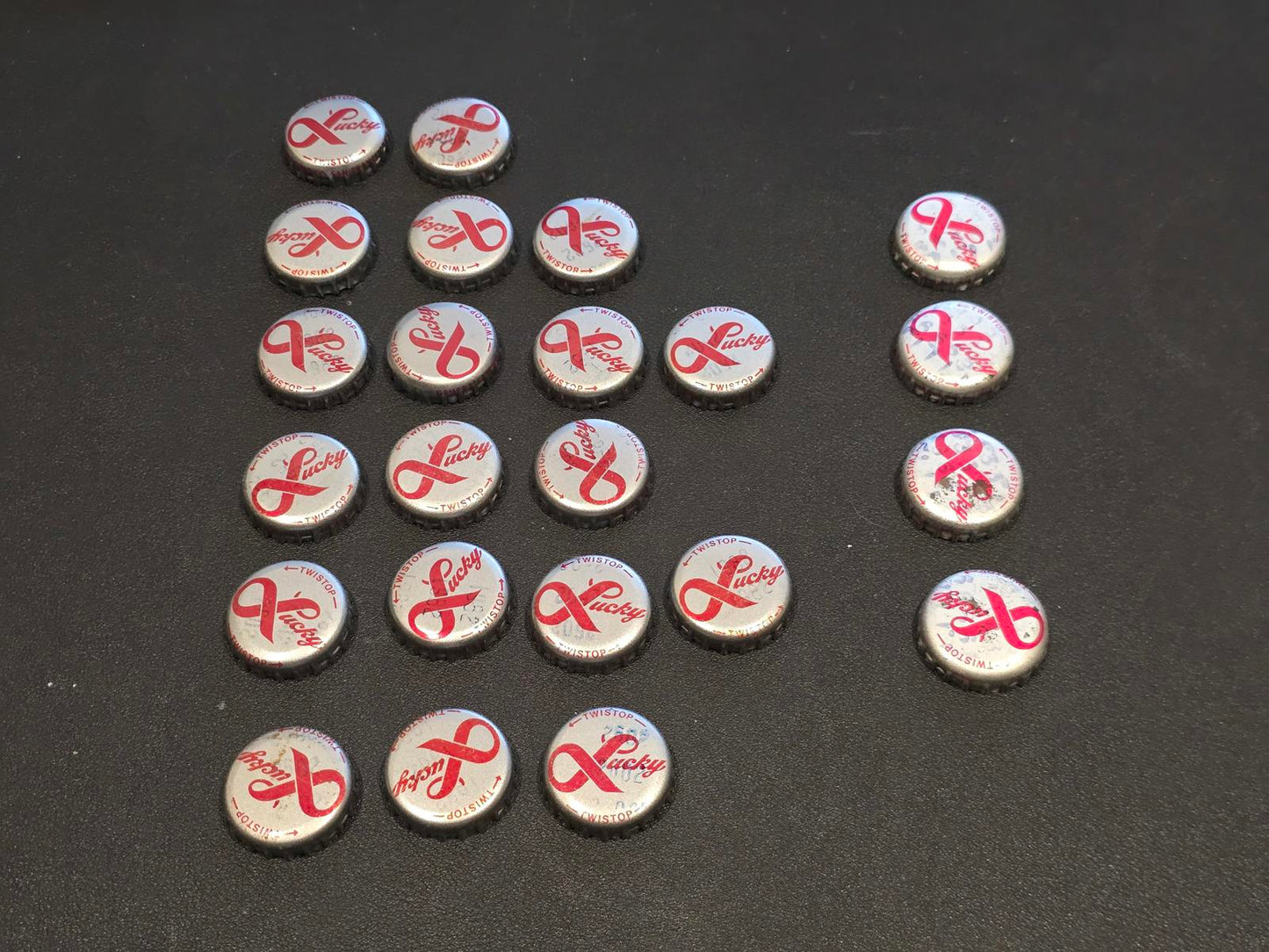 Set of 76 Lucky Lager Rebus/Puzzle Bottle Caps - Silver w/ Red Script