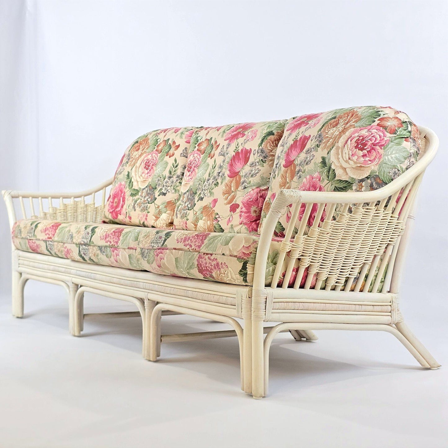 Whitewashed Rattan Sofa with Floral Cushions